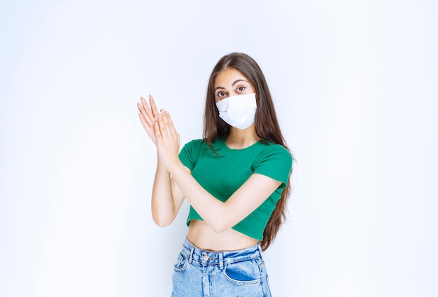 Portret van mooie jonge vrouw in medisch masker poseren voor de camera.