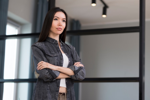 Gratis foto portret van mooie jonge vrouw met gekruiste armen