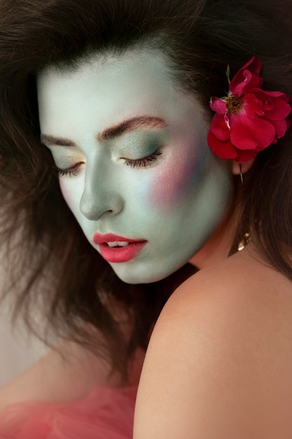 Portret van mooie jonge vrouw met kleurrijke gezichtsmake-up