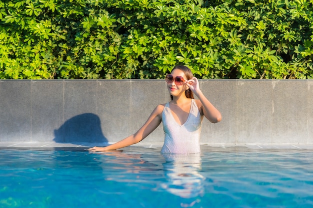 Portret van mooie jonge vrouw ontspannen bij het zwembad