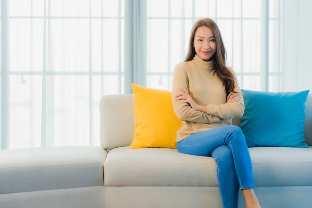 Portret van mooie jonge vrouw op bank in de woonkamer