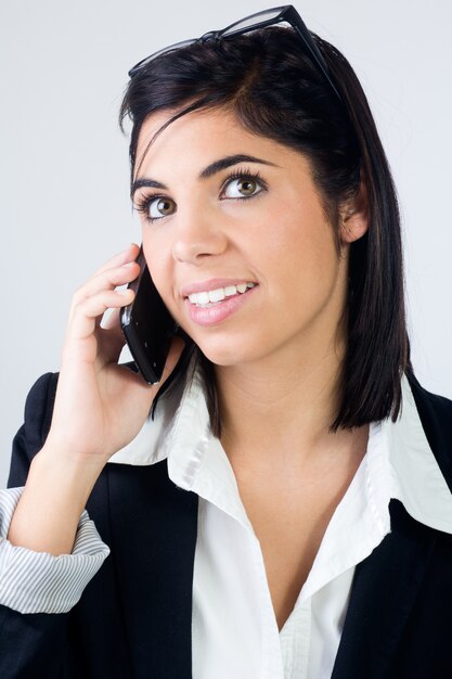 Portret van mooie jonge vrouw op kantoor met mobiel.