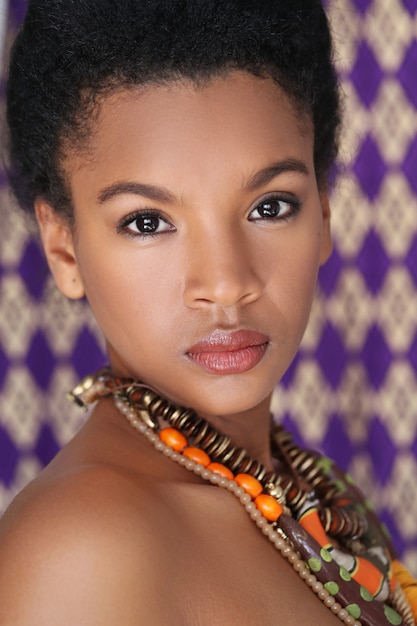 Portret van mooie jonge zwarte met traditionele Afrikaanse halsband