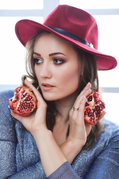 Portret van mooie maniervrouw met granaatappelfruit