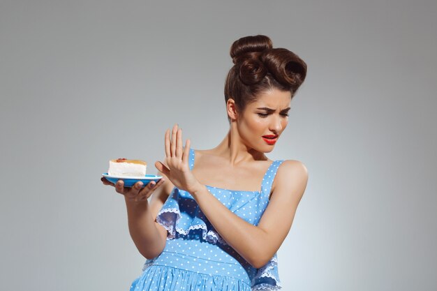 Portret van mooie pin-up vrouw weigert taart te eten