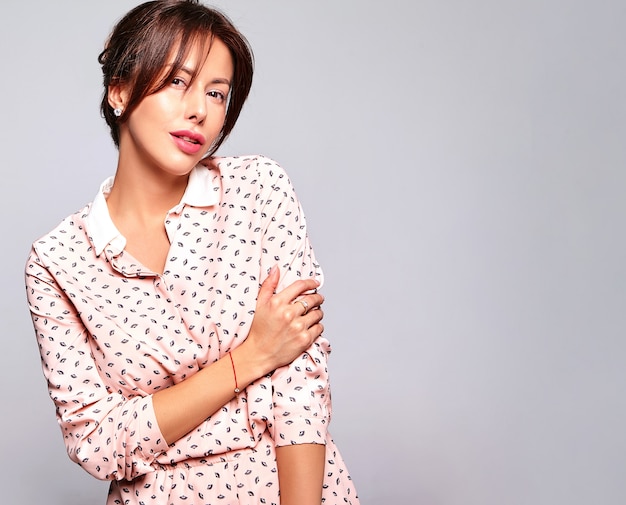 Portret van mooie schattige brunette vrouw model in casual zomer kleding zonder make-up geïsoleerd op grijze muur