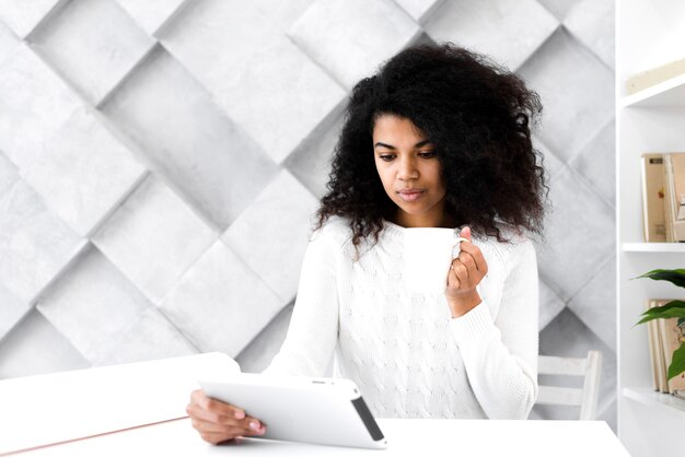 Portret van mooie volwassen vrouw die een tablet houdt