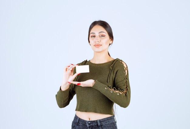 Portret van mooie vrouw die blanco visitekaartje toont.