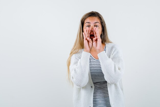 Portret van mooie vrouw die een geheim in jas vertelt en geheimzinnig vooraanzicht kijkt