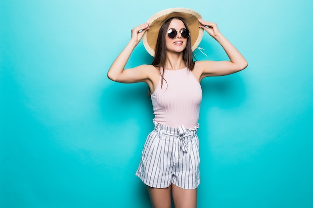 Portret van mooie vrouw in zonnebril en hoed over blauwe kleurrijke muur. Zomer roeping.