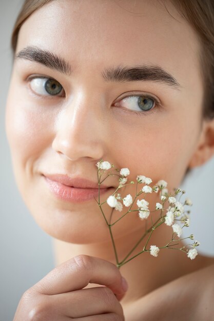 Portret van mooie vrouw met heldere huid poseren met baby's adem bloemen