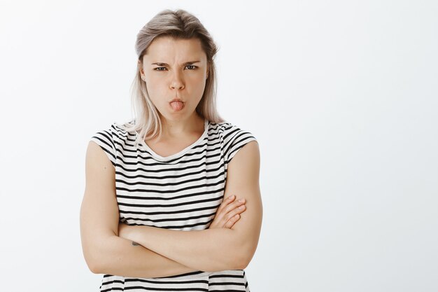 Portret van ongehoorzaam blond meisje poseren in de studio