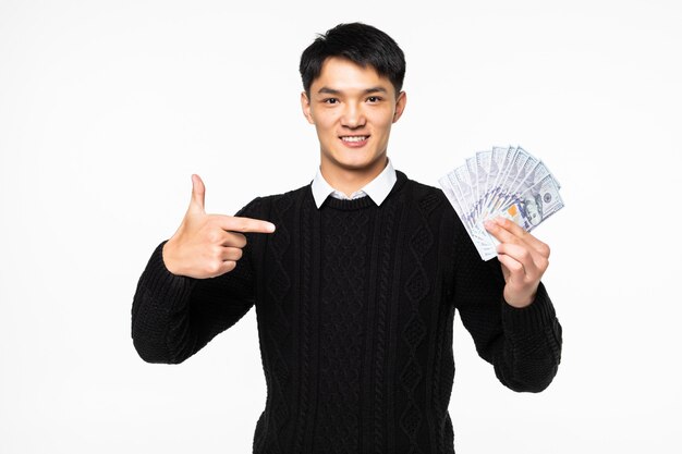 Portret van opgewonden Chinese man pointe op veel bankbiljetten geïsoleerd op een witte muur