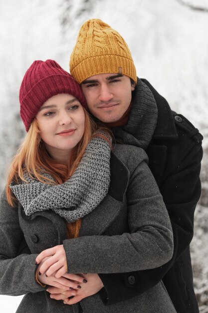 Portret van paar dat in openlucht in wintertijd koestert