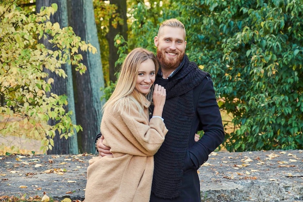 Portret van paar op de datum. Roodharige bebaarde man knuffelen schattige blonde vrouw in een herfst park.