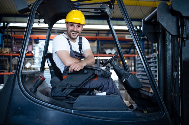 Portret van professionele heftruckchauffeur in het magazijn van de fabriek