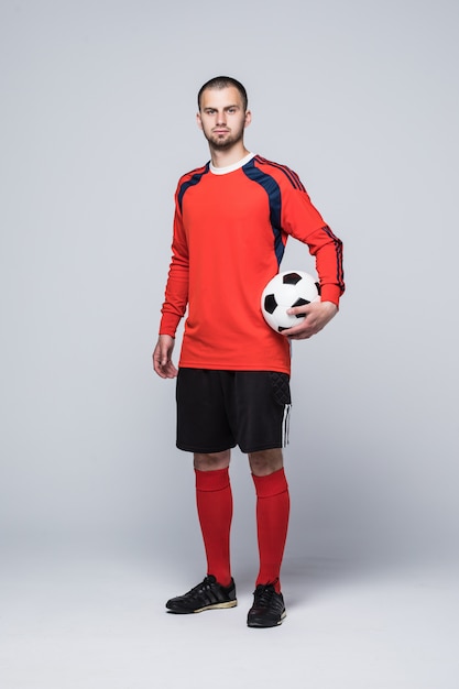 Gratis foto portret van professionele voetballer in rood overhemd dat op wit wordt geïsoleerd