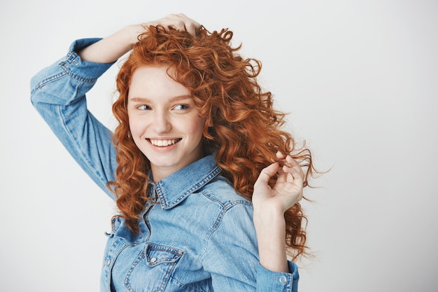 Portret van roodharige het mooie meisje glimlachen die in kant kijken. Kopieer ruimte.