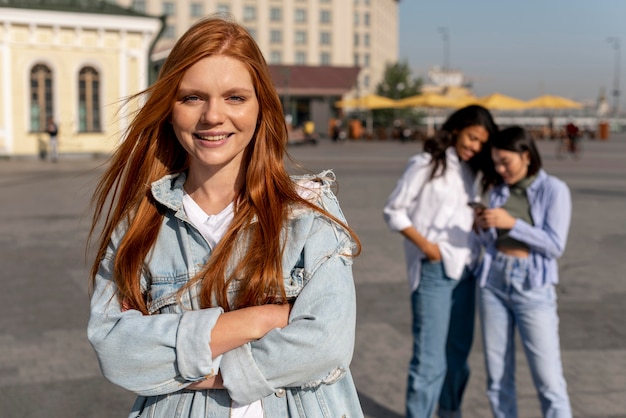 Portret van roodharige vrouw naast vrienden