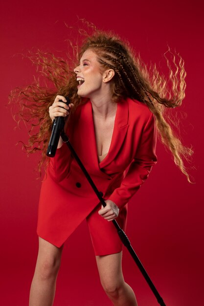 Portret van roodharige zingende vrouw met microfoon