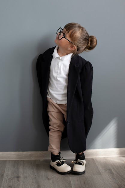 Portret van schattig meisje in oversized jas en bril