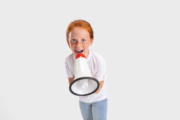 Portret van schattig sproeten roodharig meisje in casual outfit poseren geïsoleerd op witte studio achtergrond Gelukkige jeugd concept Sunny child