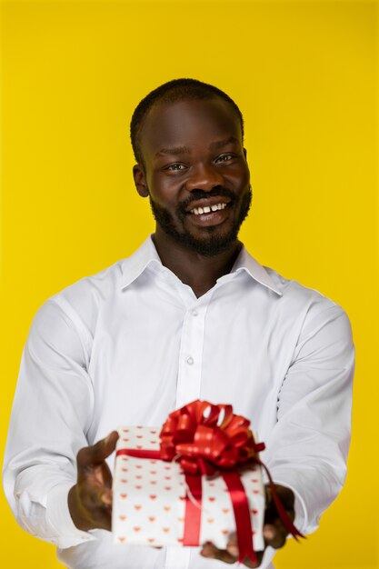 Portret van schattige Afrikaanse man die een geschenk geeft