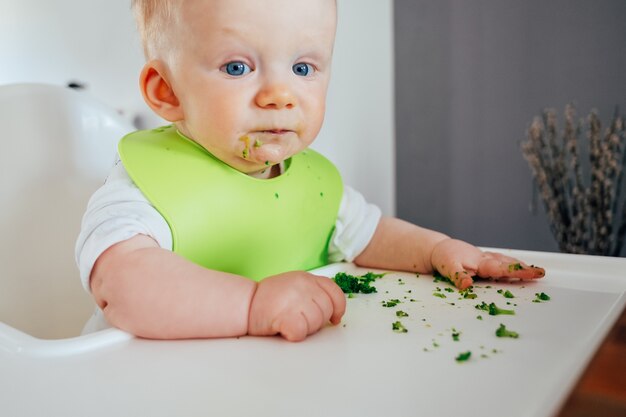 Portret van schattige babymeisje zitten slordig na het voeden