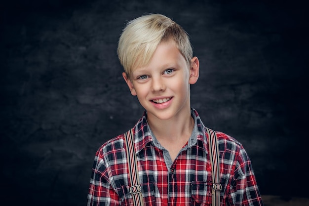 Portret van schattige blonde tiener in een shirt op grijze achtergrond.