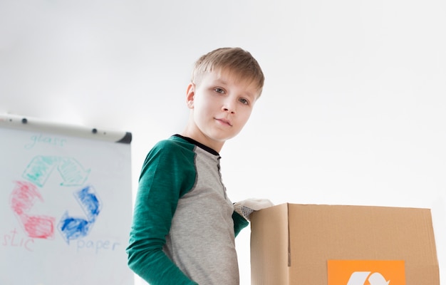 Gratis foto portret van schattige jonge jongen leren hoe te recyclen