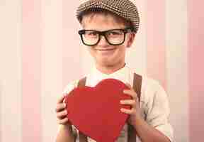 Gratis foto portret van schattige kleine jongen met valentijnsdag geschenk