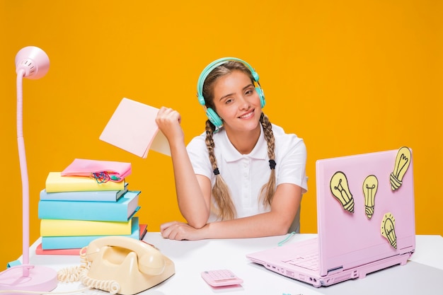 Portret van schoolmeisje dat met laptop bestudeert