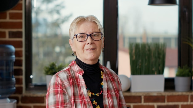 Gratis foto portret van senior artiest die tekentechniek leert tijdens workshop, met behulp van kunstacademieprogramma om artistieke hobby uit te leggen. educatieve klasse om creatieve schetsen op canvas te tekenen. uit de hand geschoten