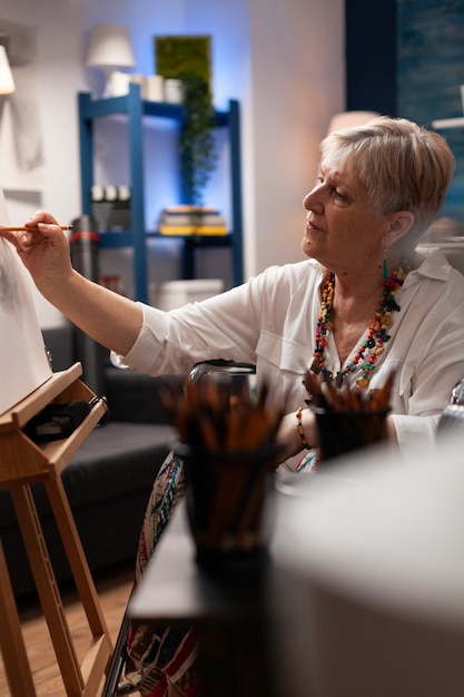 Portret van senior artiest zittend in rolstoel in studio