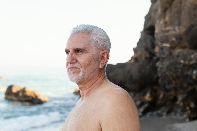 Portret van senior grijsharige man op het strand