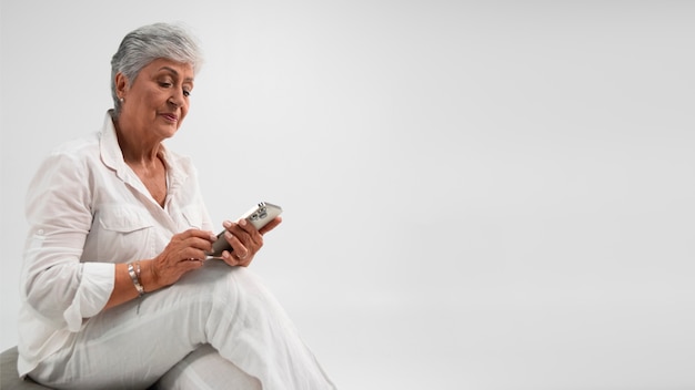 Gratis foto portret van senior vrouw met smartphone