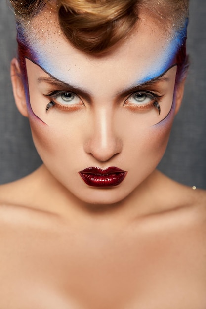 Portret van serieus volwassen meisje met kleur make-up in studio Premium Foto