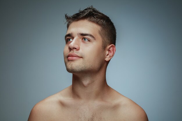 Portret van shirtless jongeman geïsoleerd op grijze studio