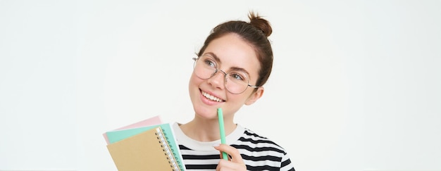 Gratis foto portret van slim meisje met bril tutor met pen en notebooks student draagt haar huiswerk notities