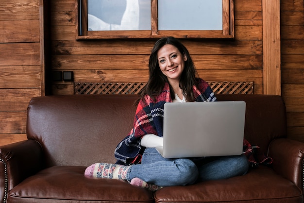 Portret van smiley jonge vrouw op een bank