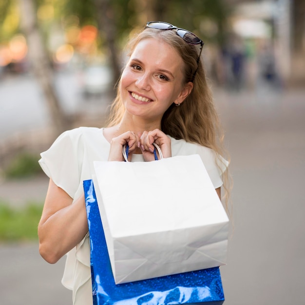 Portret van smiley vrouw met boodschappentassen