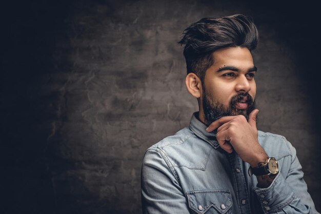 Portret van stijlvolle bebaarde Indiase man gekleed in een spijkerjasje.