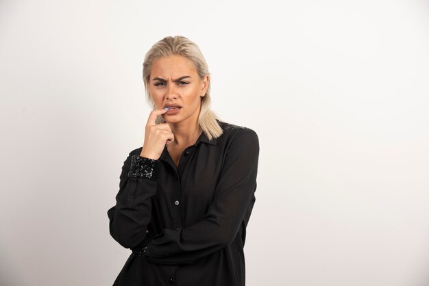 Portret van stijlvolle vrouw in zwarte shirt poseren op witte achtergrond. Hoge kwaliteit foto