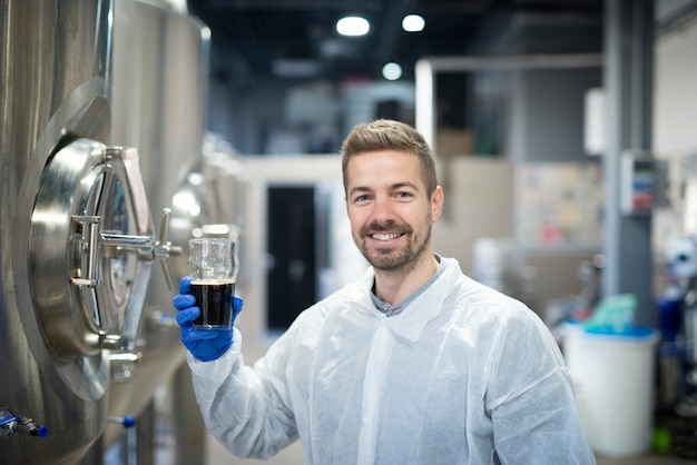 Portret van technoloog die productkwaliteit test in de fabriek van de drankalcoholproductie