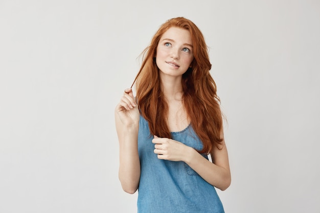 Portret van tedere dromerige sproeterige gembervrouw die denkt, zich onzeker voelt over haar eerste date. Opgroeien tot prachtige jonge vrouw. Op wit plannen. Twenties concept.