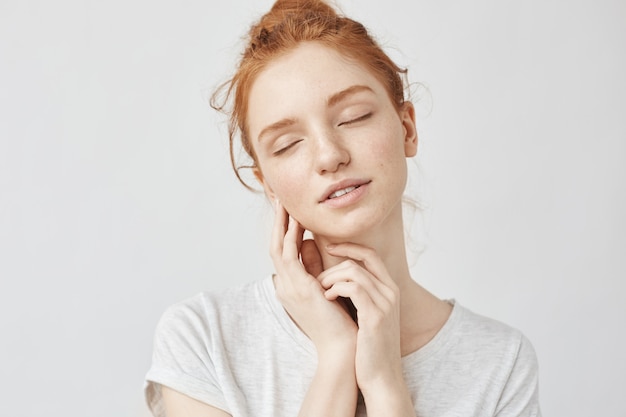 Portret van tedere vrouw met foxy haar en gesloten ogen glimlachen.