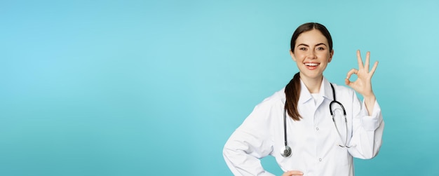 Portret van tevreden glimlachende medische werker vrouw arts die oke ok nul geen probleem gebaar toont ex