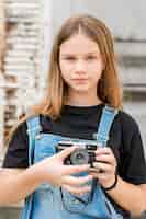 Gratis foto portret van tiener mooi meisje die retro camera