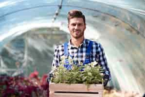 Gratis foto portret van tuinman met houten kist met zaailing