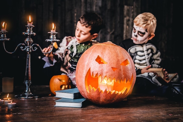 Portret van twee coole schooljongens in enge kostuums tijdens Halloween-feest in een oud huis. Halloween-concept.
